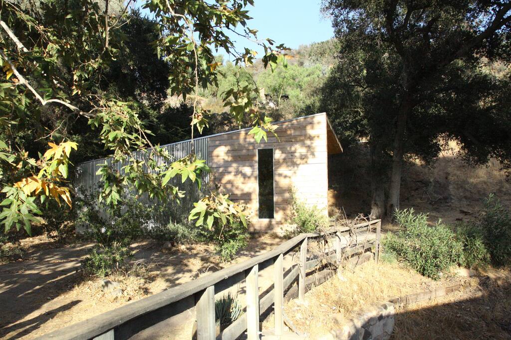 House is across a private bridge next to a seasonal stream.