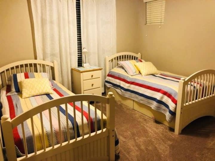 Twee eenpersoonsbedden en een matras met twee eenpersoonsbedden op de grond onder één eenpersoonsbed