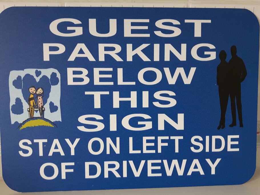 Watch for this sign on the front of the house near the green bush and on the house.