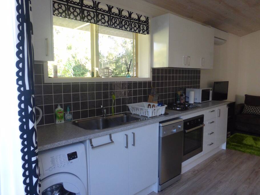 Kitchen with dishwasher, washing machine, microwave, job and oven. Fridge freezer.