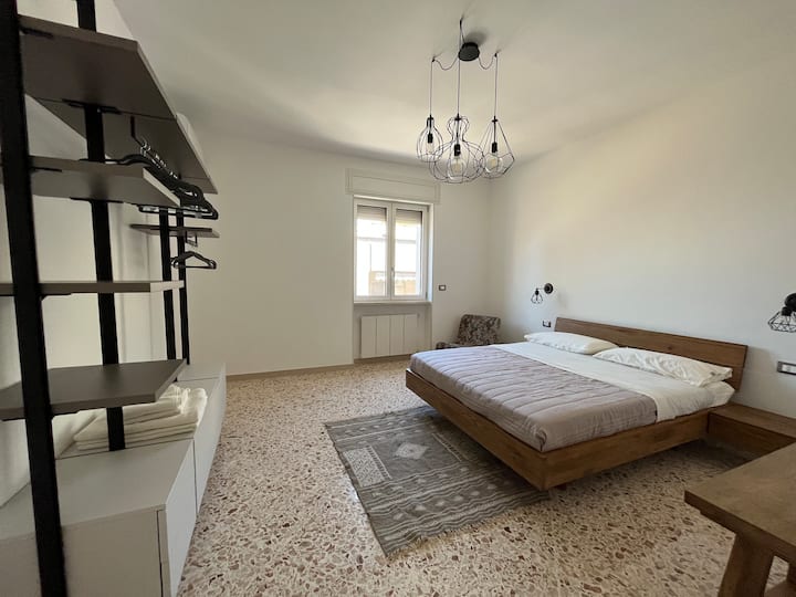 Kitanda cha watu wawili kilicho na kabati kubwa na dawati. Kitanda cha mtoto kinapoombwa