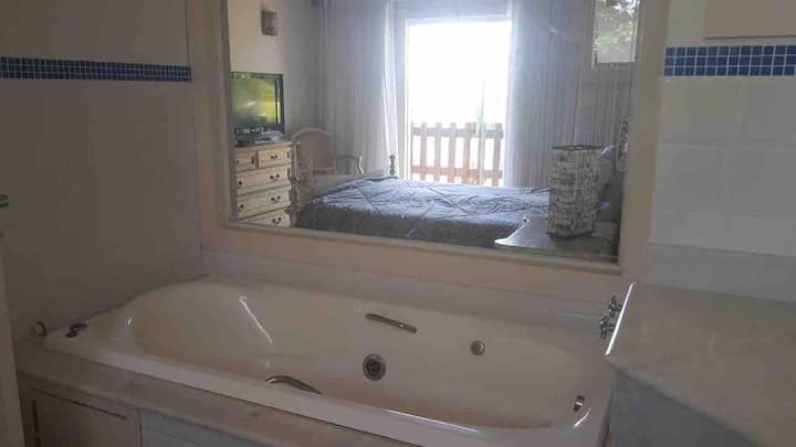 حمام في الجناح الرئيسي يُرى من الداخل إلى الخارج، مع زجاج.