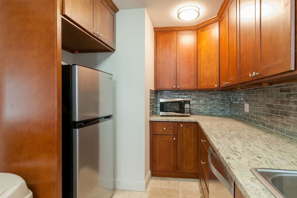 View of refrigerator, microwave and plenty of counter top space.