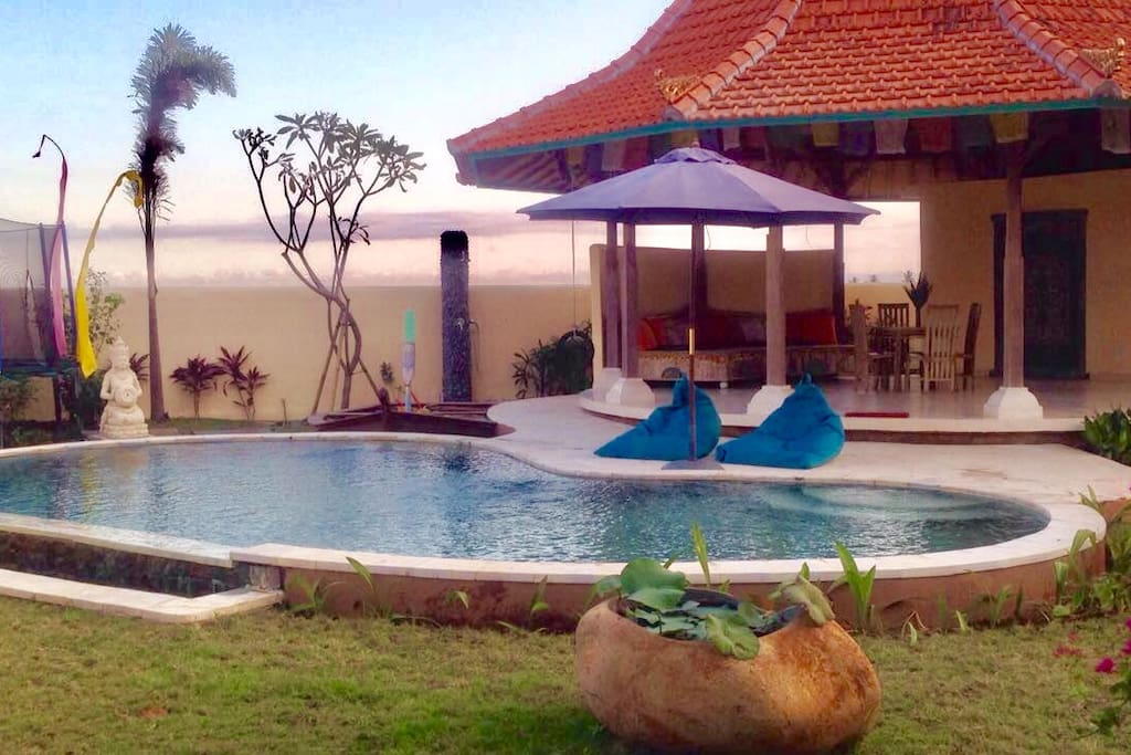 View of 9 m private pool, pavilion living area with huge sofa and dining, boatshaped sandpit and trampoline family friendly .