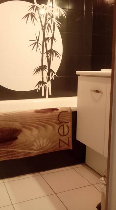 Salle de bain avec baignoire , sèche cheveux , serviettes