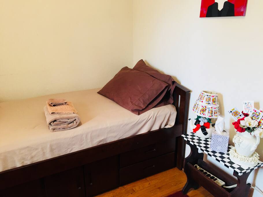 Guest room with built in dresser, armchair, desk, night stand and closet.