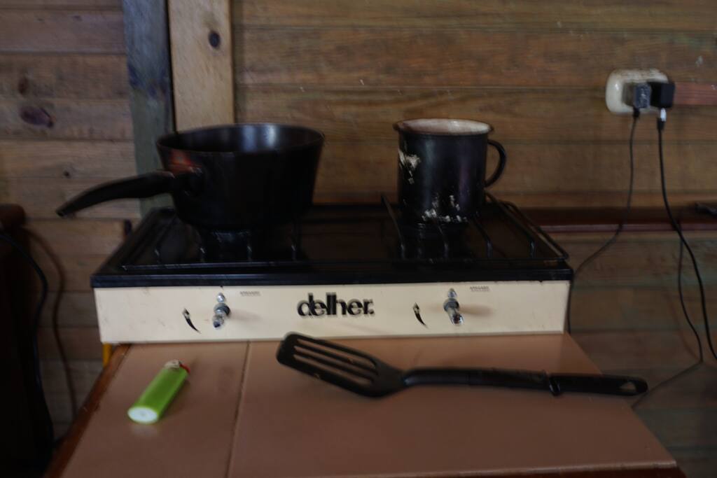 Cocina a gas con dos fogones y cocinilla eléctrica de un fogón. Con todo tipo de utensilios de cocina, ollas, sartenes...
