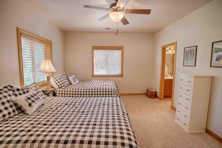 Dormitorio loft norte con dos camas tamaño queen, un escritorio, un vestidor y un baño completo privado. 