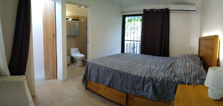 ¡Sube la escalera de hierro abierta hasta el dormitorio loft con baño privado y un balcón! Una cabecera retroiluminada, cortinas opacas, ventilador de techo y una unidad de aire acondicionado dedicada te permiten crear el entorno perfecto para una buena noche de sueño. 