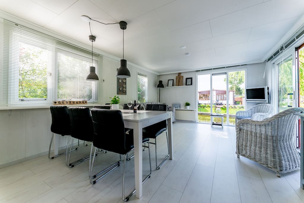 Lichte woonkamer met lange eettafel en comfortabele stoelen