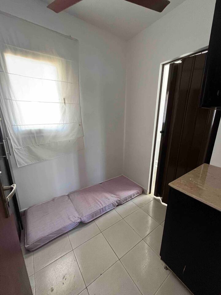 Chambre de nounou avec matelas au sol et salle de bain attenante