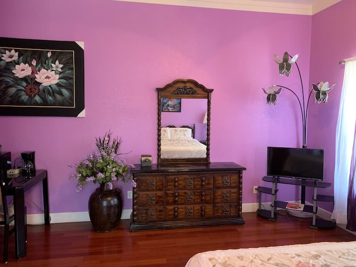 The Purple Suite. Smart TV, Dresser with Mirror and Table.  The second floor of the south wing was built in 1913.  This room and four others were rented out on the top floor.  The original five rooms were extensively remodeled in 2008-9.