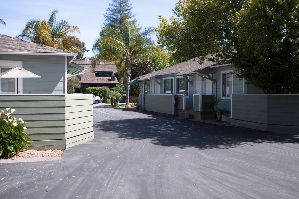 View of the building structure from the private driveway. The photo is taken from the location of the unit's dedicated parking space. The driveway opens up to the tree-lined and low-traffic residential street called Live Oak Avenue in downtown Menlo Park.