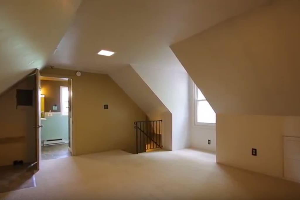 Stairway opens up into a multi-purpose space, where washer and drier are available for your use (not pictured here). Full bathroom in the back of this photo.