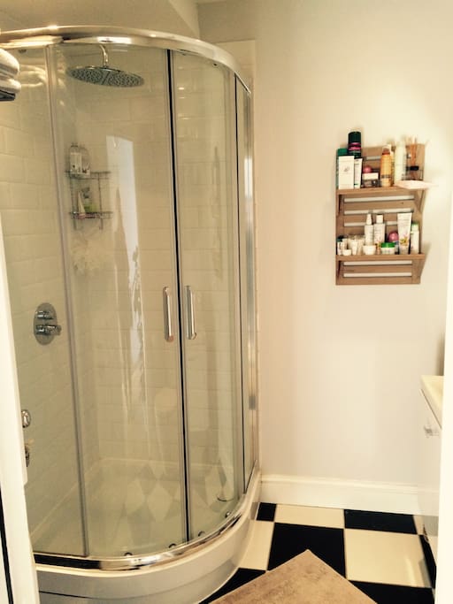 A large shower with a monsoon shower head