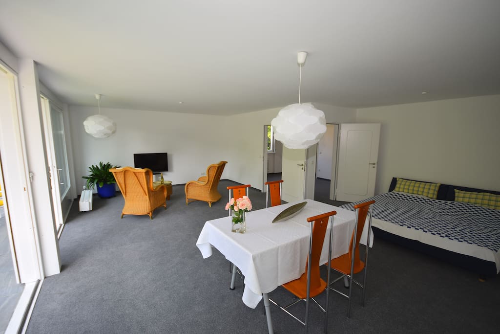 Main living room with table, 4 chairs and a wide double bed