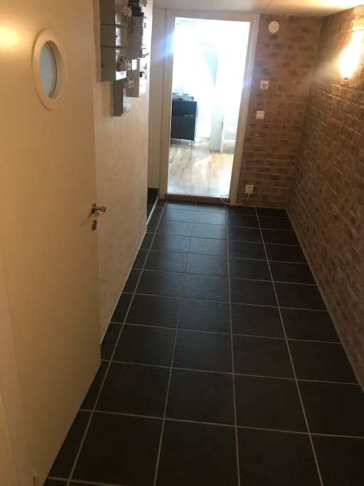 Hallen vid källaringången mot köksdelen, badrum till höger.