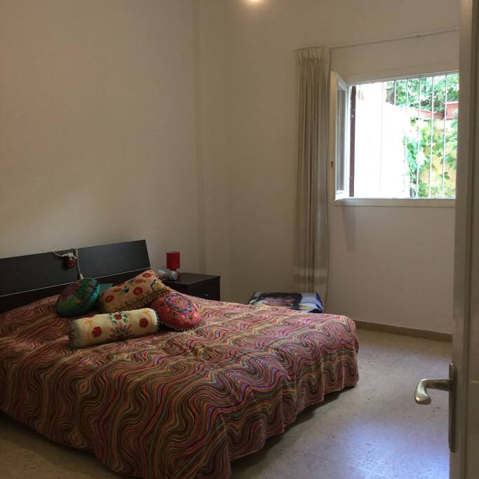 La chambre principale avec fenêtre sur jardin