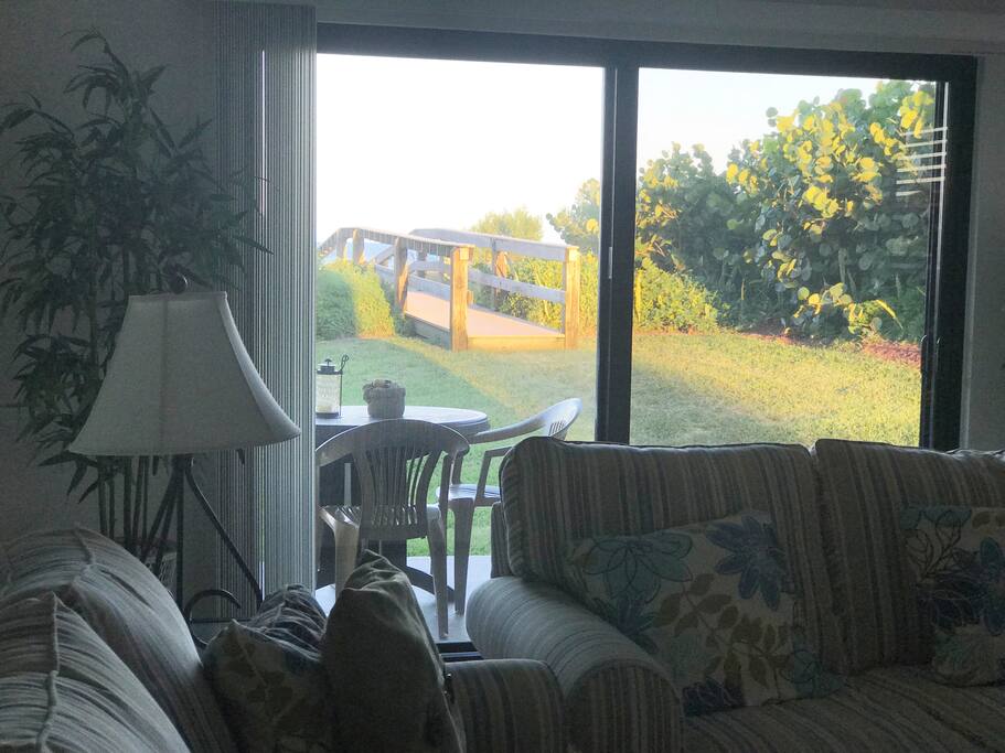 Inside Living Room view of patio and walkway to the beach . You really will not find a closer Ocean Front rental to the Ocean where you can hear the waves and Ocean 24/7 and the beach is so conveniently close. The perfect spot inside and out.