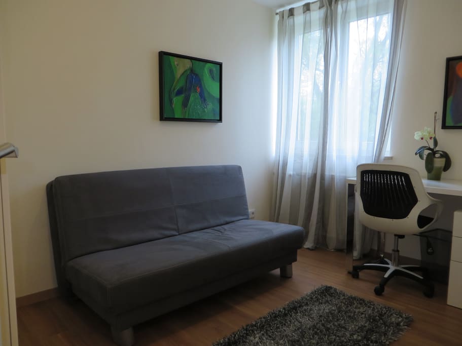 2tes Zimmer mit Schlafcouch, Kleiderschrank und Arbeitsplatz.