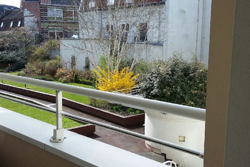 Balcon avec petite table et vue sur le parc privé de la résidence