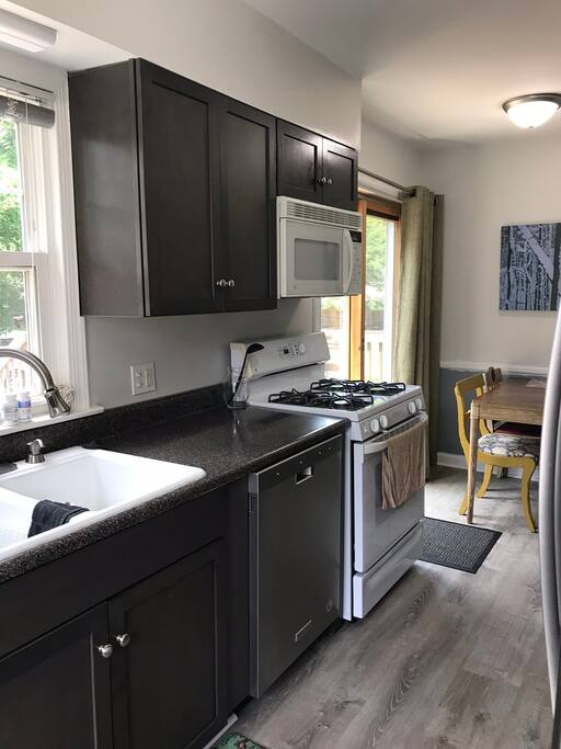 Kitchen has a gas stove with new refrigerator and dishwasher.