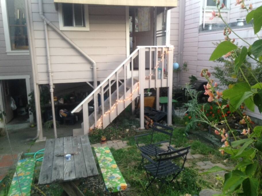 Backyard with grill. Garden full of flowers and veggies.