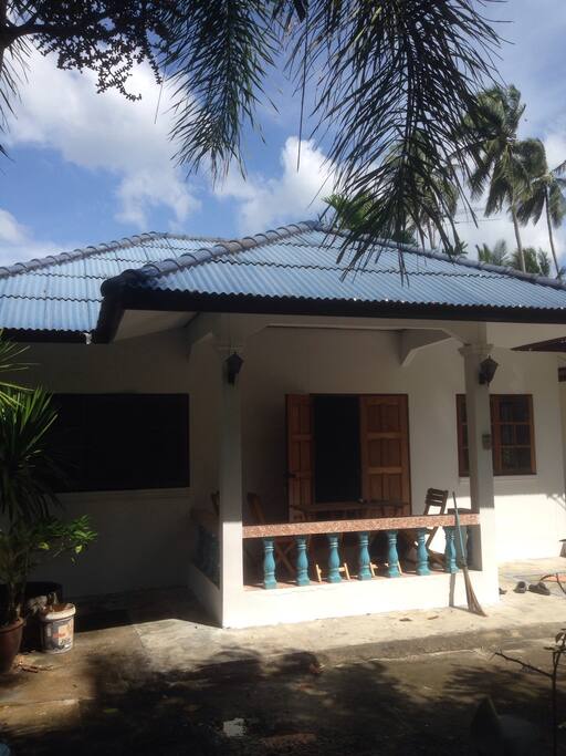 Covered Outdoor sitting area, has two small tables and 6 chairs