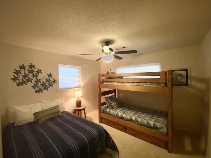 Segundo dormitorio con cama de tamaño completo y literas.