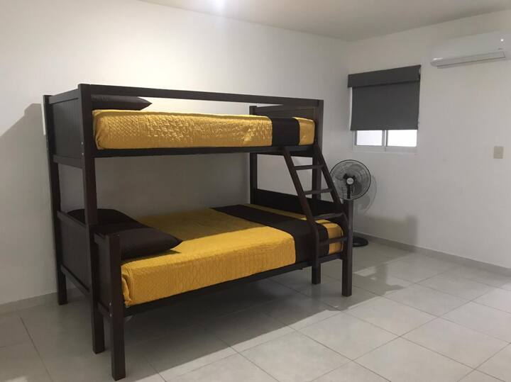 أسرّة بطابقين وسرير بحجم كبير في الطابق السفلي والطابق العلوي