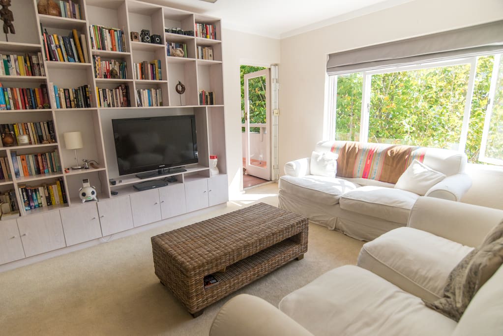 Spacious and sunny - our lounge area with comfy couches, a huge flat screen TV and all our books.