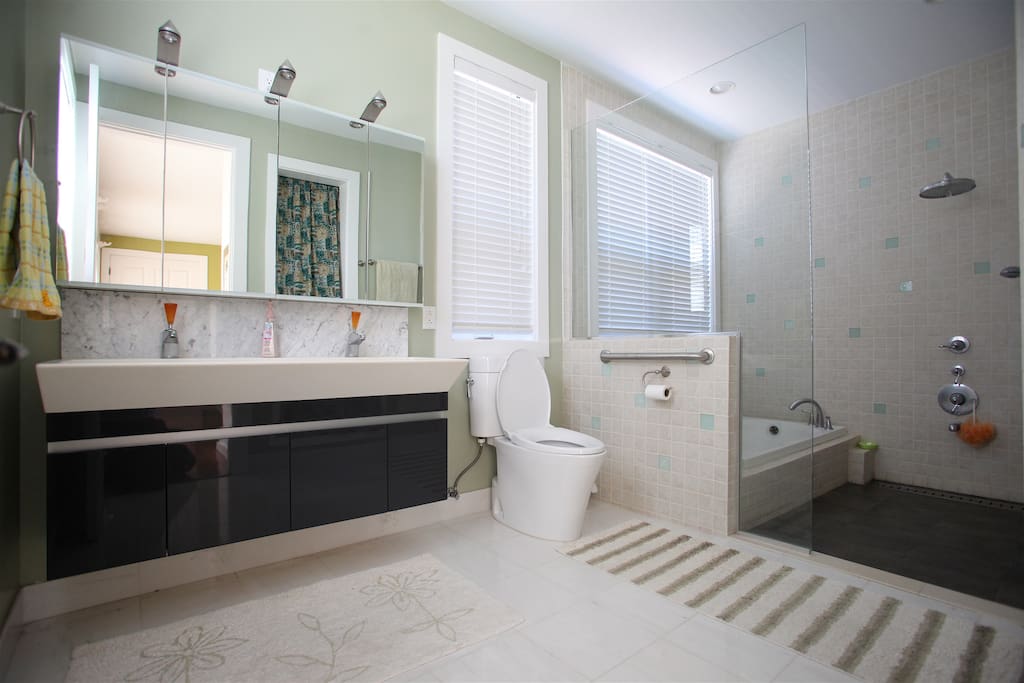 A better bath than a hotel! spacious and bright with a jacuzzi and double wash basin with lots of storage space behind the mirrors.