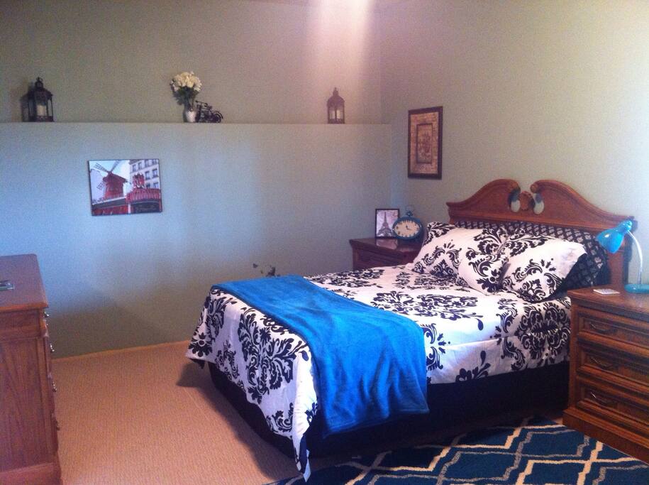 The huge master bedroom with a queen-size bed, dresser, and night stands.