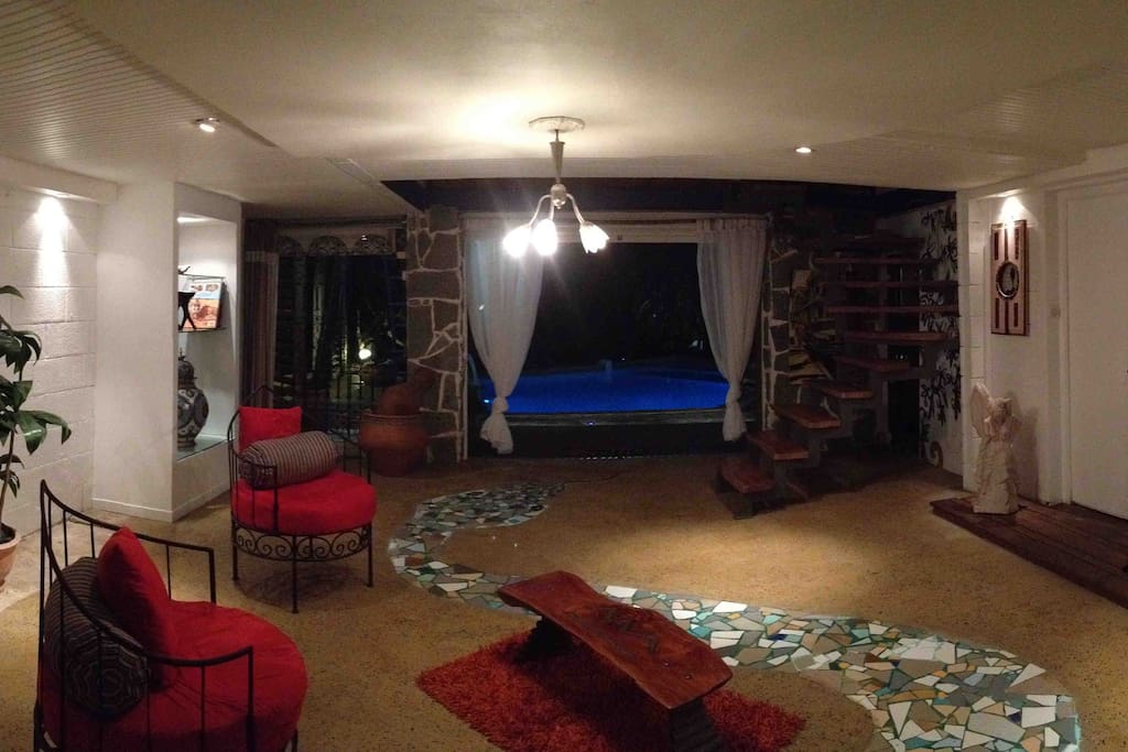Vue de nuit sur la piscine depuis le patio