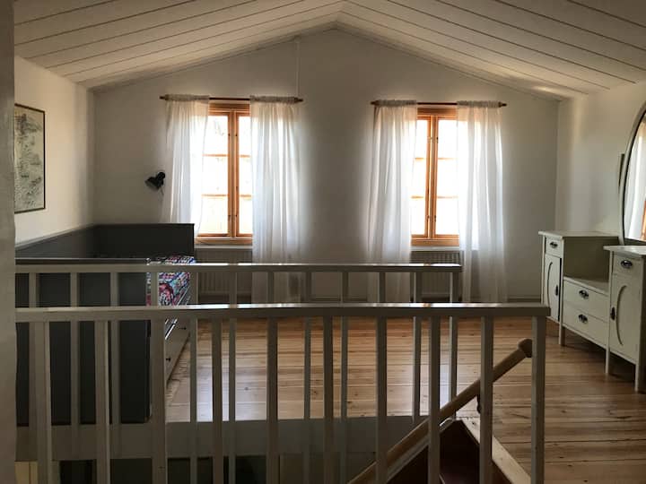 غرفة معيشة مشرقة مع سرير أريكة في الطابق العلوي