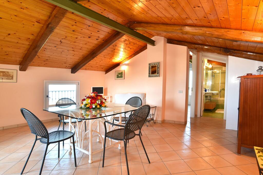 Salotto con zona pranzo, divano e TV
