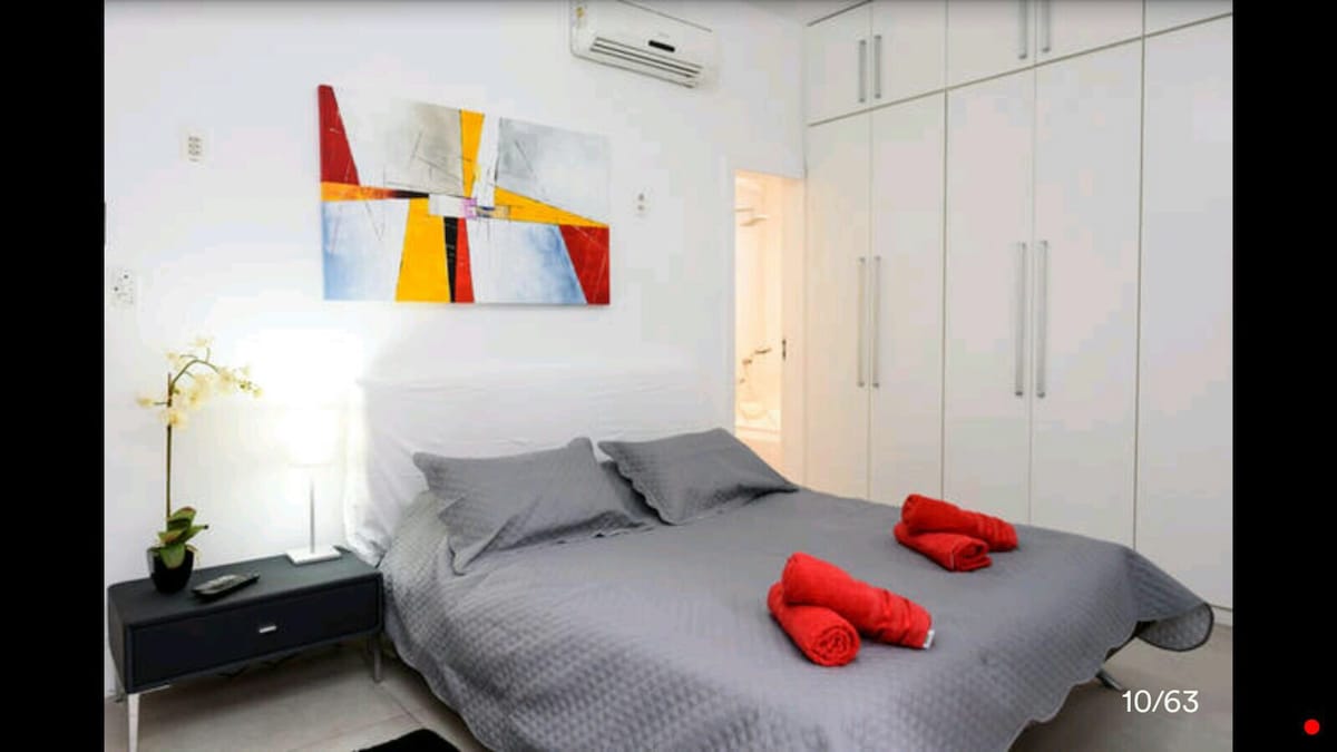 غرفة نوم رئيسية جميلة في الجناح مع حمام خاص ومكيف هواء ومروحة سقف