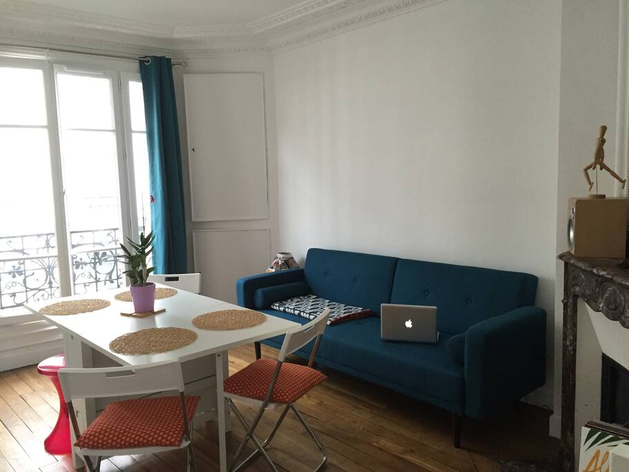Espace commun, espace à vivre avec parquet, moulure et cheminée.
