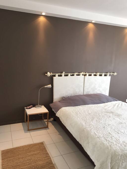 Chambre principale avec lit queen size et fenêtre.