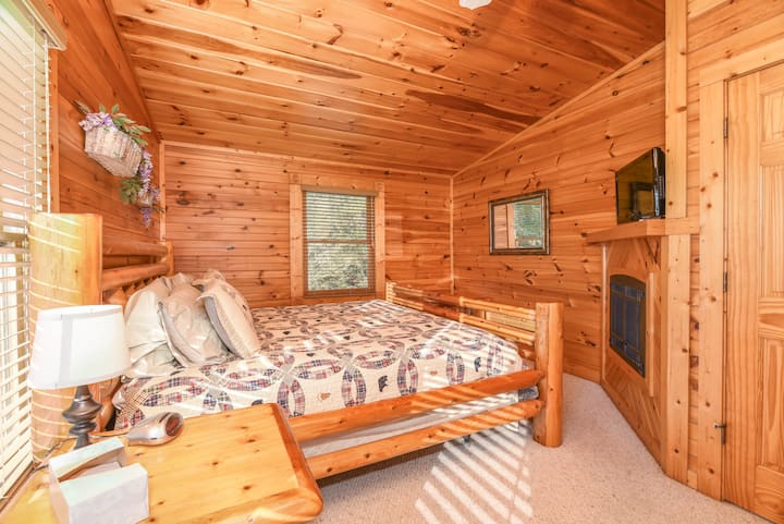 Dormitorio principal en la planta superior con una cama tamaño king, chimenea eléctrica y televisión.
