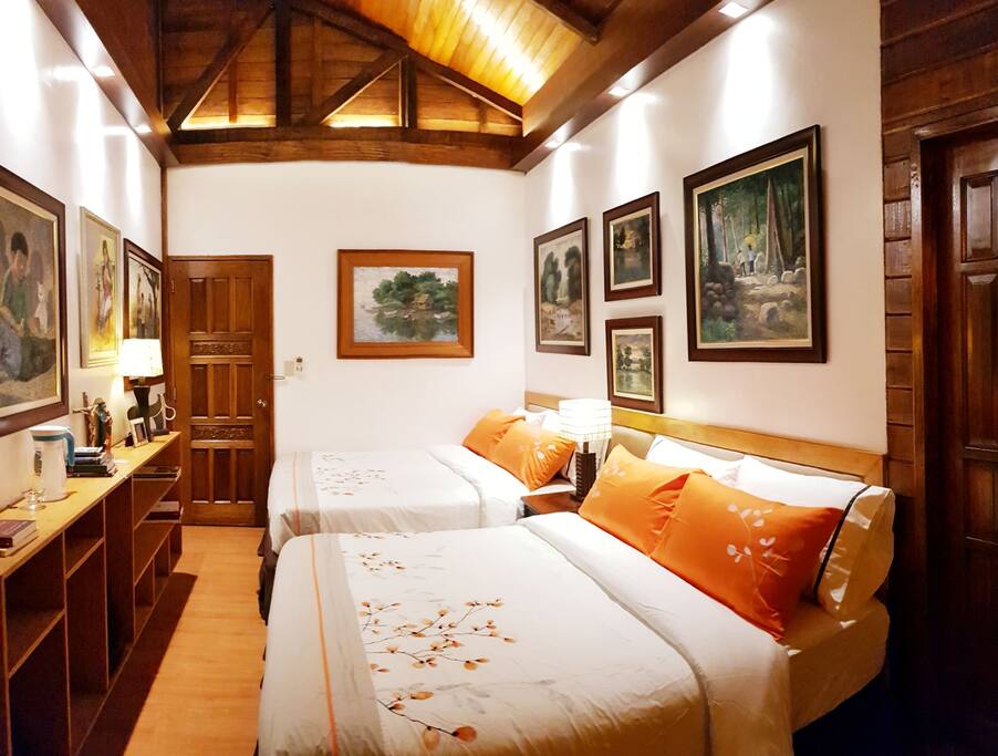 Bedroom 1 with 2 queen size beds is adorned mostly with paintings of Raul Agas, known for using an ATM card to paint instead of a brush.
