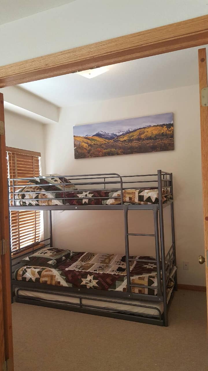 Zimmer auf der Hauptebene mit zwei Einzelbetten, Etagenbetten und einem 3. Ausziehbett für zwei Personen.