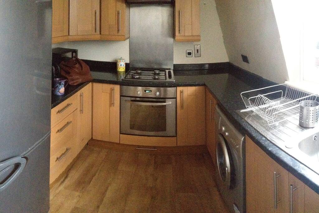Kitchen fitted with oven, gas hob, grill, washing machine, fridge, kettle and toaster.