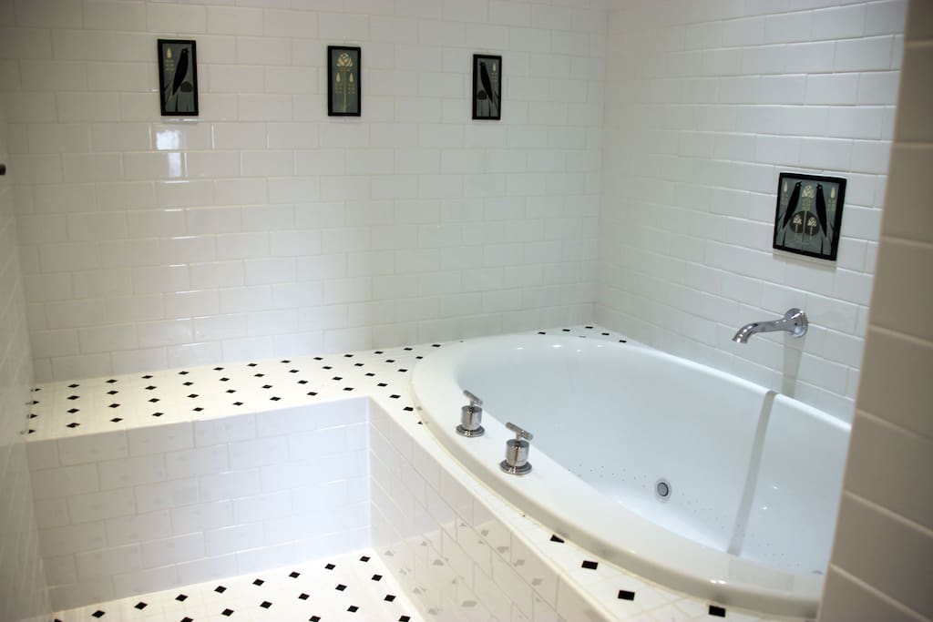 Private bath has a rain shower and Kohler spa tub