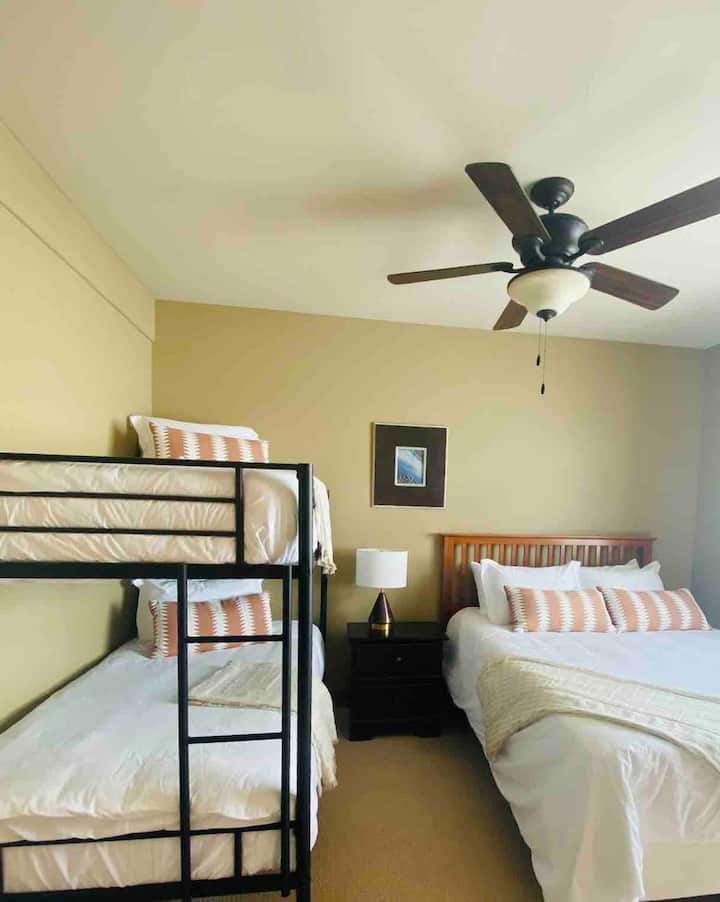 ห้องนอนรองมีเตียงแฝดเหนือเตียงสองชั้นพร้อมเตียงควีนไซส์