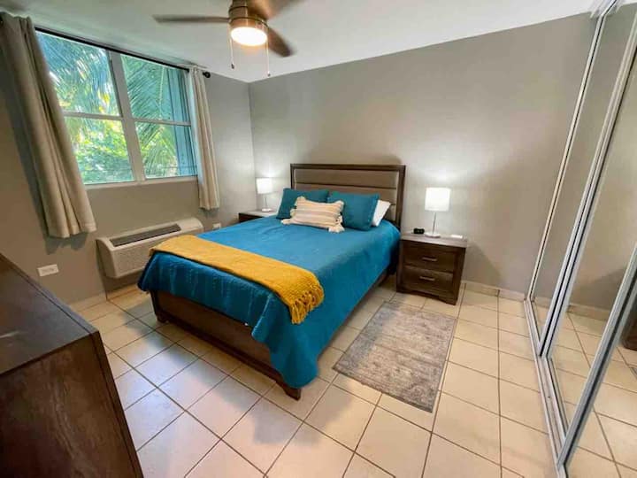 غرفة نوم رئيسية بسرير بحجم كبير ووحدة مكيف ومروحة. 