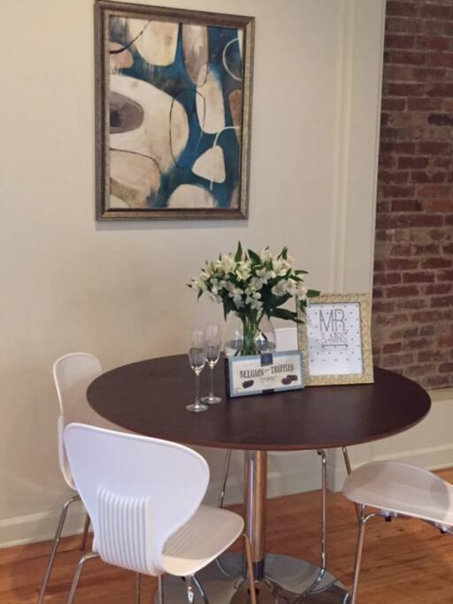 The new kitchen mid century dining table with fresh flowers and welcome note and chocolates