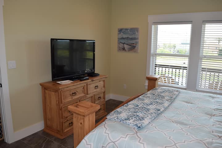 Брачна спална соба со телевизор и поглед кон залив