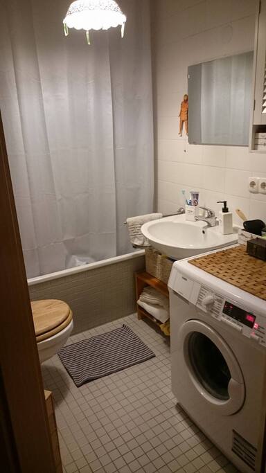 Kleines Bad mit Waschmaschiene und Badewanne