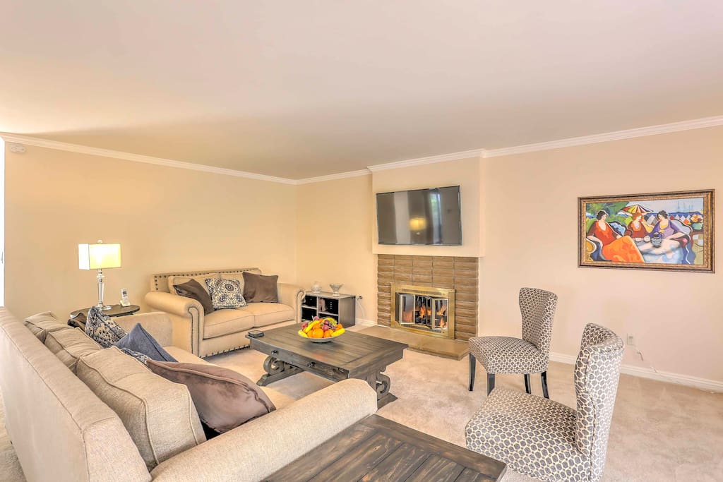 The pristine living room has brand new carpets and a slump stone fireplace.